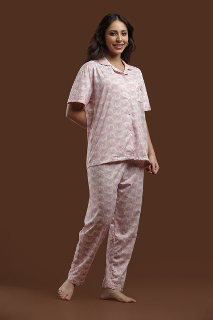 Side-angle view of the Koozy women's PJ set with pink bows on an off-white background. The photo showcases the fluid drape of the comfortable cotton fabric and the easy-going silhouette.