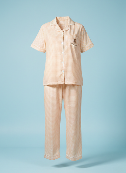 Ghost mannequin shot of the Koozy light peach checkered pajama set, showcasing the structured fit of the button-down short-sleeve shirt and matching long pants. This Pinterest-style cotton nightwear suite highlights the breathable fabric and relaxed silhouette for a soft, easy, and cozy look.