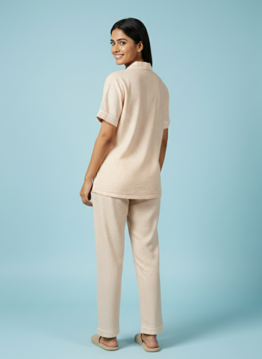 full-length back view of the koozy light peach pj set for women, styled with matching neutral slides against a soft blue backdrop. this breathable cotton set offers a relaxed and inviting morning look.