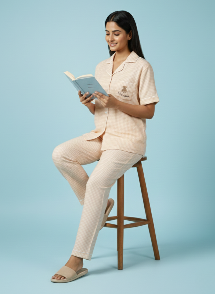 Relaxing view of the light peach and white check pattern on the Koozy pajama pants. Emphasizing the high-quality, breathable cotton material and clean, comfortable finish of this nightwear suite.