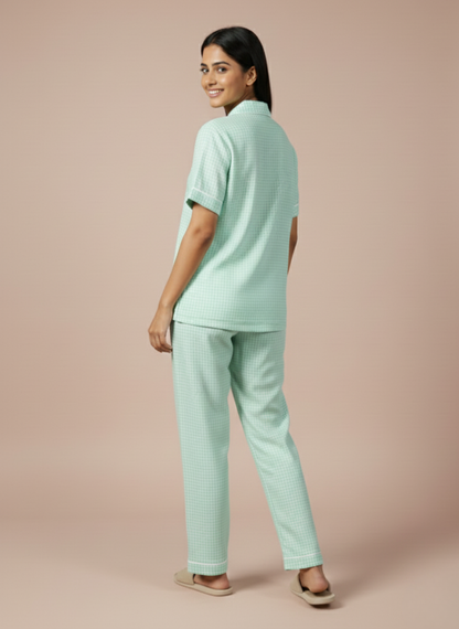 Back shoot view of the Koozy light mint green PJ set for women, styled with matching neutral slides. This breathable cotton set offers a relaxed and inviting morning look, perfect for a cozy aesthetic.