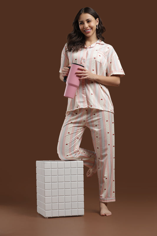 Effortlessly cute and comfortable Koozy pajama set in a pink heart print. A Pinterest-style cotton, breathable fabric nightwear suite designed for a soft, easy, and cozy look. Relaxed fit, light-colored, and beautifully printed PJ set for women.